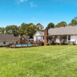 side view of home with pool and firepit for entertaining friends
