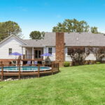back of home with pool and firepit